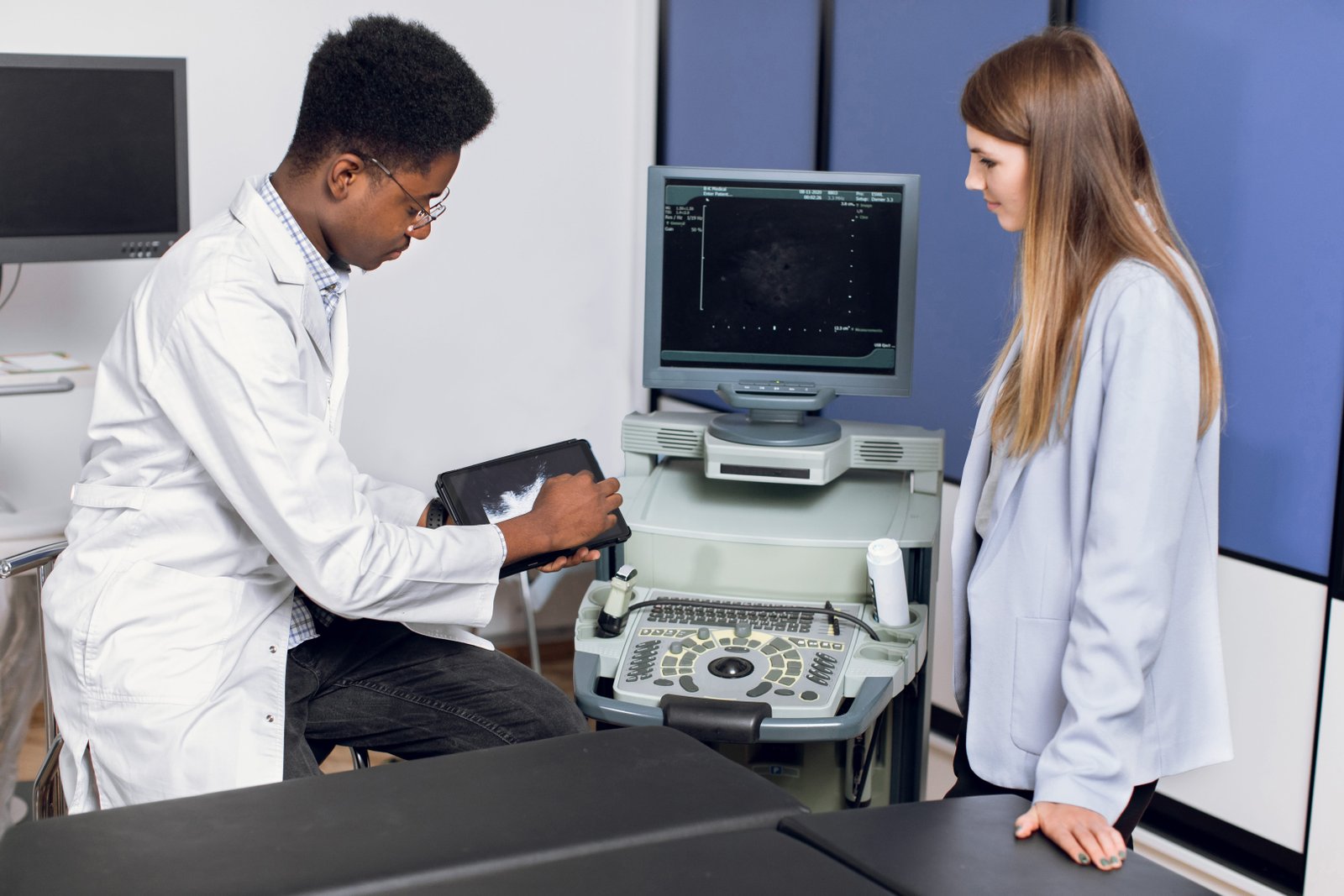 Young male african doctor in modern clinic, holding tablet pc